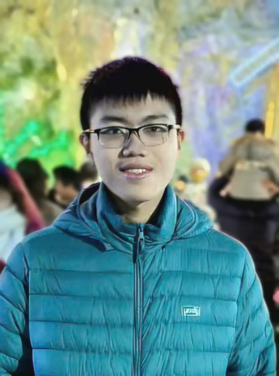 a smiling boy wearing glasses in a blue jacket